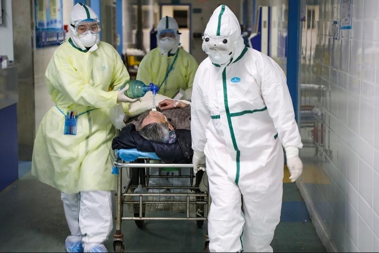 Medical workers in protective suits move a patient inside an isolated ward of a hospital in Wuhan, Hubei province, China, February 6.