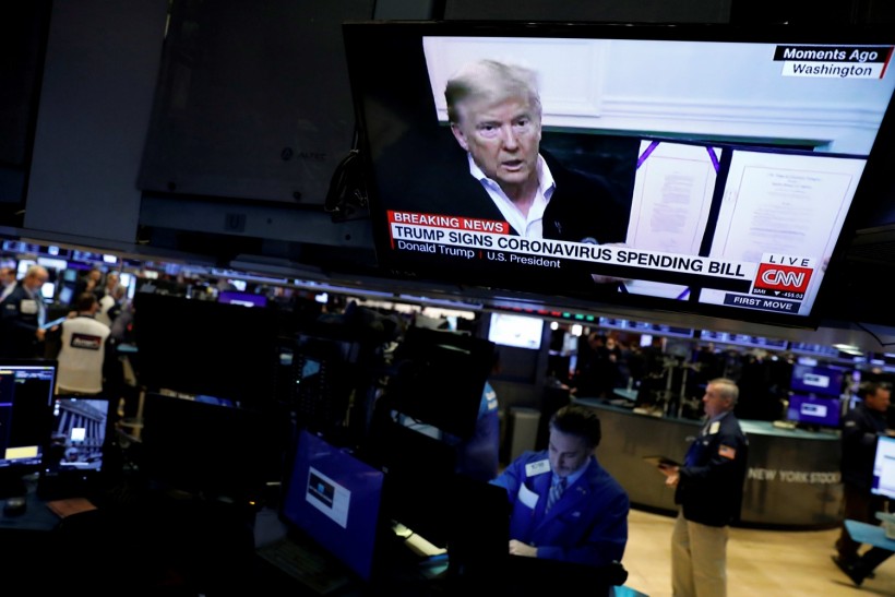 FILE PHOTO: U.S. President Donald Trump is seen on a news broadcast discussing the coronavirus spending bill on the trading floor at the New York Stock Exchange (NYSE) in New York City