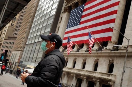 A man wears a mask to prevent exposure to the coronavirus disease (COVID-19) while walking past the New York Stock Exchange