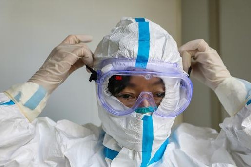 A doctor puts on protective goggles before entering the isolation ward at a hospital, in Wuhan, January 30