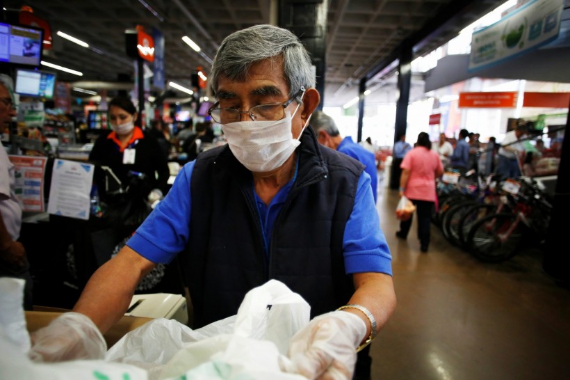 An elderly man, working as a packer at a supermarket, wears a protective face mask as a security measure for the coronavirus disease (COVID-19), in Mexico City