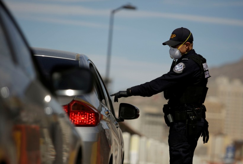 U.S. Customs and Border Protection police officer talks to a driver as the coronavirus disease (COVID-19) outbreak continues at Paso del Norte International Border bridge as taken from Ciudad Juarez,