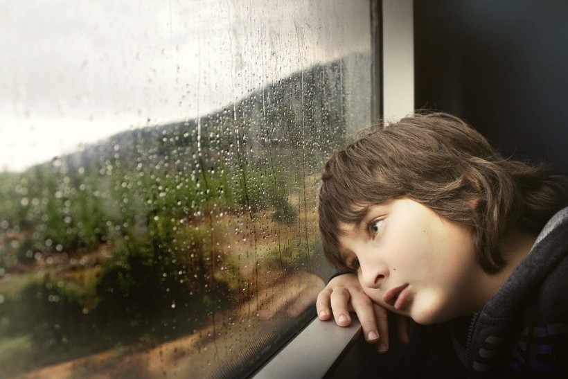 Sad kid staring out window