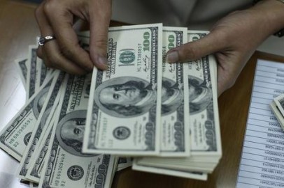 FILE PHOTO: An employee counts U.S. dollar notes at a money changer in Jakarta January 27, 2010.