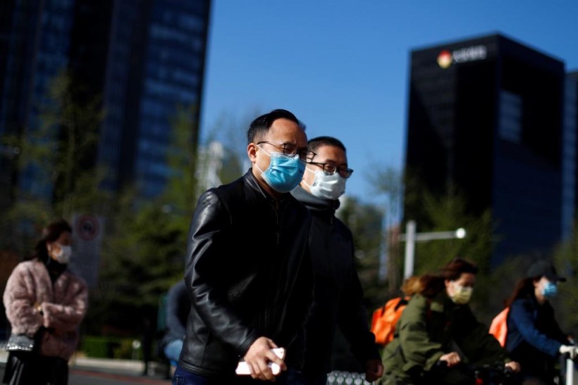 People wear masks as they head to work during morning rush hour, amid the outbreak of coronavirus disease (COVID-19), in the central business district in Beijing, China