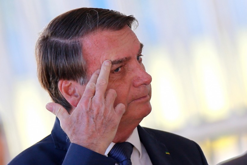 Brazil's President Jair Bolsonaro gestures while meeting supporters as he leaves Alvorada Palace, amid coronavirus disease (COVID-19) outbreak, in Brasilia