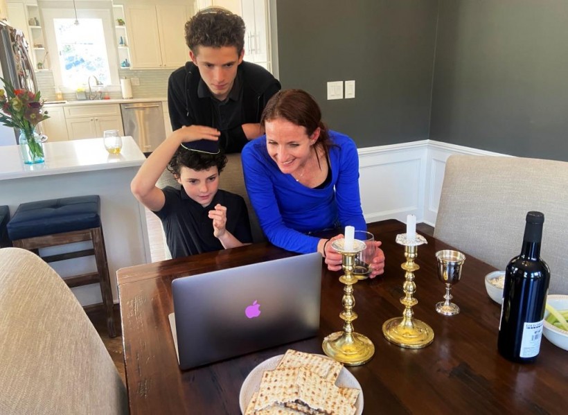 Cheryl Noah and Alex Barkin use a computer during a family Passover Seder to connect with relatives who are unable to gather together due to the outbreak of Coronavirus disease (COVID-19) in Maplewood, New Jersey, U.S