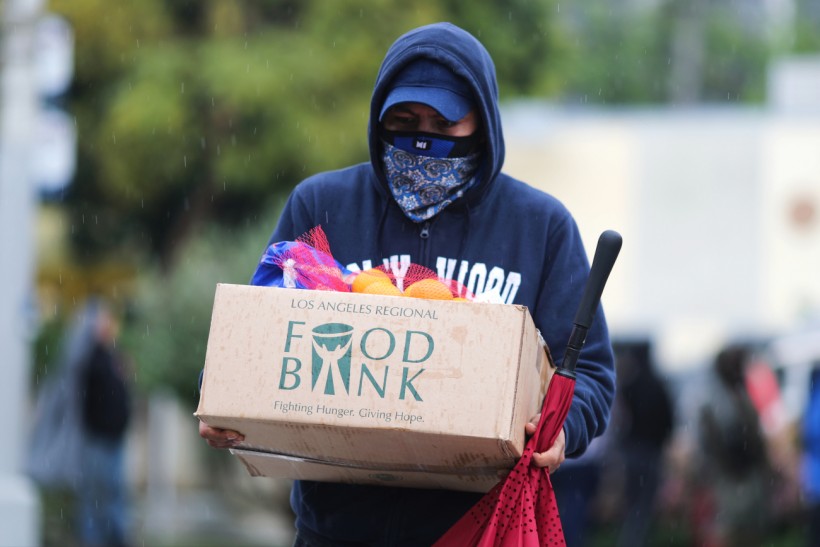A man carries away fresh food at a Los Angeles Regional Food Bank giveaway