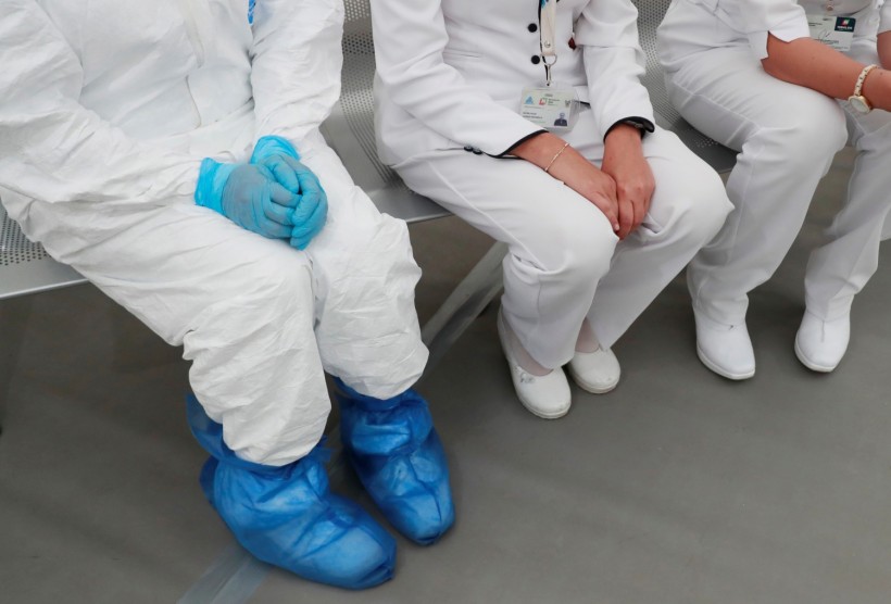 A medical specialist wearing protective gear sitting next to two nurses inside the new immediate response mobile hospital in Pachuca
