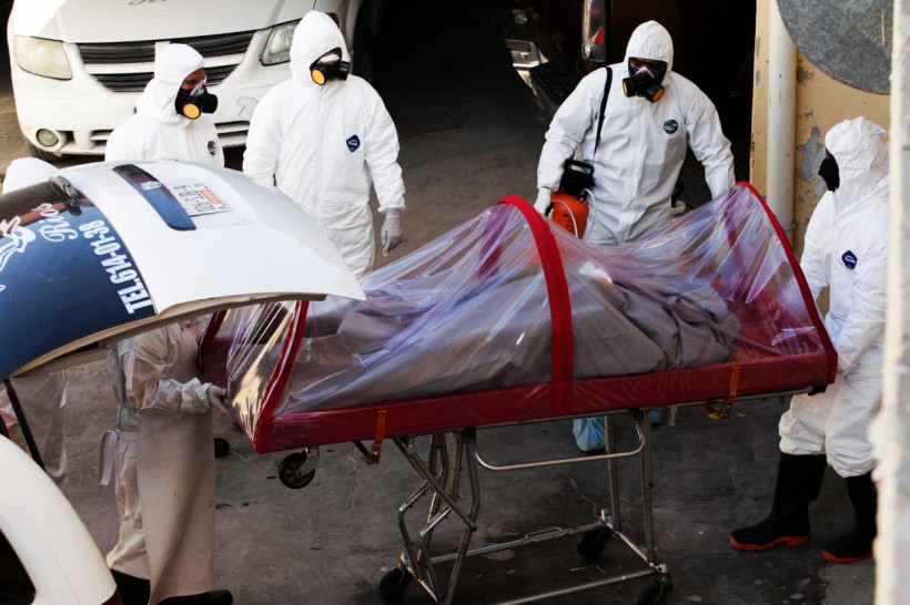 Funeral workers remove the body of a coronavirus disease (COVID-19) victim from a hearse at a funeral parlor, in Ciudad Juarez, Mexico