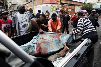 Residents carry dead bodies after a police operation against drug gangs in Rio de Janeiro