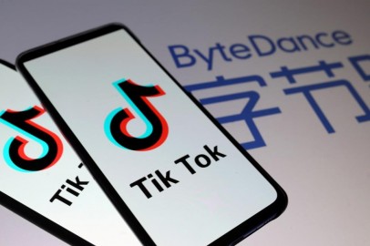 Tik Tok logos are seen on smartphones in front of a displayed ByteDance logo in this illustration.