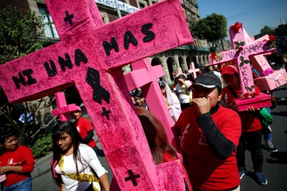 Women carry pink crosses during the 