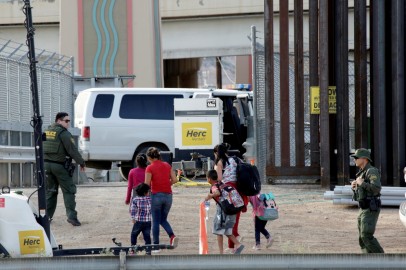 CBP agents look at migrants who crossed illegally into El Paso, Texas, U.S. to turn themselves in to ask for asylum as seen from Ciudad Juarez