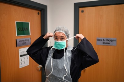 Doctor Nathalie Dukes puts on personal protective equipment (PPE)