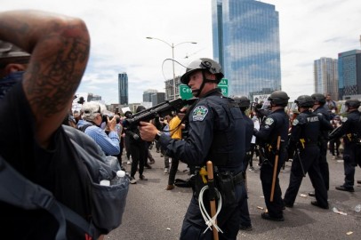 An Austin police officer points his weapon after protesters threw rocks and bottles during a rally against the death in Minneapolis police custody of George Floyd, in Austin, Texas, US