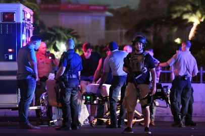  Police officers stand by as medical personnel tend to a person on Tropicana Ave. near Las Vegas Boulevard after a mass shooting