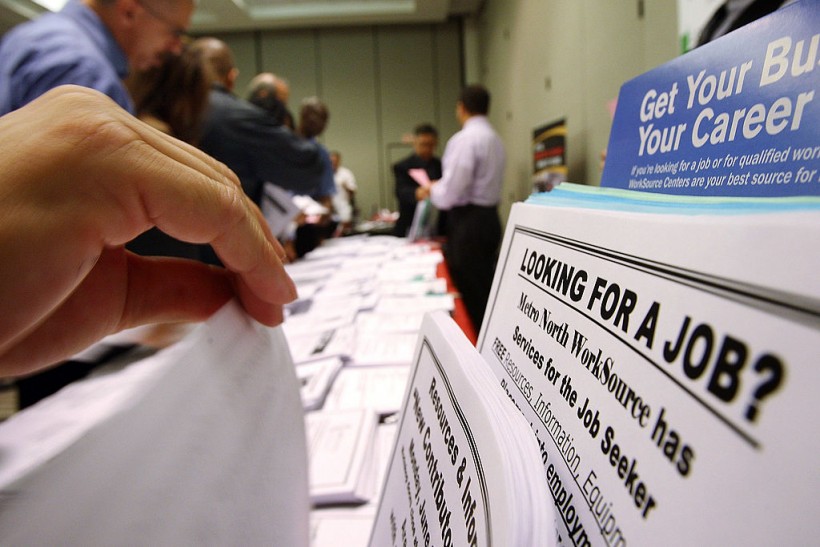 Job seekers look over job opening fliers 