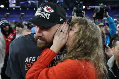 Taylor Swift guards herself from any would-be lip-readers while whispering into the ear of boyfriend Travis Kelce last month