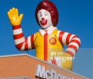 A giant Ronald McDonald sits atop a McDonald's fast food restaurant