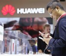 Visitors try out the Huawei Mate S smartphone at the Huawei stand at the 2015 IFA consumer electronics and appliances trade fair on September 4, 2015 in Berlin, Germany. 