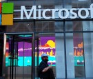 A man passes a Microsoft office in New York on October 6, 2015. Microsoft introduced a pair of big-screen smartphones and a laptop during an event in New York on Tuesday. 