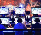 Gamers wear headsets as they sit at a bank of monitors and play Activision Blizzard Inc.'s Heroes of the Storm computer game at the Gamescom video games trade fair in Cologne, Germany.