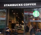 Customers sit inside a Starbucks Corp. coffee shop in the Khan Shatyr Shopping and Entertainment Center, designed by Foster + Partners Ltd, in Astana, Kazakhstan, on Wednesday, Nov. 23, 2016.