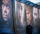 Woman walks past an advertising poster to promote the HBO American fantasy drama television series Game of Thrones outside the International Game of Thrones exhibition in Stockholm on March 11, 2015. 