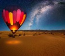 A majestic hot air balloon soars under the stars of the Milky Way, over the desert - Mesquite Dunes of Death Valley National Park. 