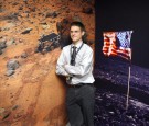 Mountain View, UNITED STATES: Chris Kemp, director of strategic business development at AMES, poses with a poster of Mars in 1996 (L) and the moon and earth in 1968 (R) at NASA's Explorer Center during a news conference 18 December 2006 at Moffett Field i