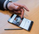 A Samsung customer browses a web page showing a fire-damaged Samsung Note 7 mobile phone, on a similar device, at a Samsung store