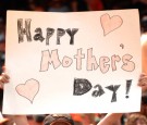 A Baltimore Orioles fan holds up a Mother's Day sign during a baseball game against the Tampa Bay Rays at Oriole Park