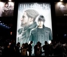 Visitors wait in line in front of an advertisement of the Final Fantasy XV video game at the Tokyo Game Show 2016 on September 15, 2016 in Chiba, Japan.