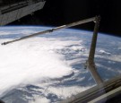 A line of thunderstorms form the backdrop for this view of the extended Space Shuttle Discovery's remote manipulator system (RMS) robotic arm while docked to the International Space Station.