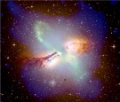 UNDATED PHOTO: A composite X-ray (blue), radio (pink and green), and optical (orange and yellow) image of the galaxy Centaurus A is shown in this image from space. A broad band of dust and cold gas is bisected at an angle by opposing jets of high-energy p