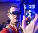 An attendee takes a photograph of himself wearing the R-9 augmented reality (AR) glasses manufactured by Osterhout Design Group Inc.