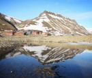 Mountains are reflected in a still section of water on the morning of Midsummer on June 21, 2008 in Longyearbyen, Norway.