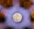 Clouds clear to allow a view of the final full moon of the year, a so-called 'Cold Moon', as it appears behind Christmas lights decorating Penzance main street on December 13, 2016 in Cornwall, Englan