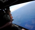 IN FLIGHT - APRIL 11: Co-pilot and Squadron Leader Brett McKenzie of the Royal New Zealand Airforce (RNZAF) P-3K2-Orion aircraft, helps to look for objects during the search for missing Malaysia Airlines flight MH370 in flight over the Indian Ocean on Apr