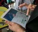 A woman plays Pokemon while commuting home from work as she stands in line for a train in Bangkok, Thailand August 24, 2016.