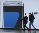 People walk past an advertisement for the Samsung Galaxy S7 Edge smartphone in Berlin, Germany. 