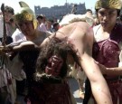 Two men dressed as soldiers carry a man portraying Jesus Christ, after his crucification, March 29, 2002 at Mexico City's Metropolitan Cathedral on Good Friday in Mexico City.