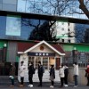 People line up to register their temperature and personal details as they arrive for work at an office building in Beijing