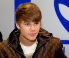 Justin Bieber poses for fans while signing autographs at a press event to unveil the mRobo Ultra Bass portable speaker