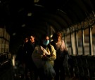 A woman wearing a protective mask carries her baby as she walks towards El Paso, Texas, U.S. at the international border bridge Paso del Norte, as seen from Ciudad Juarez