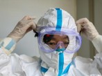 A doctor puts on protective goggles before entering the isolation ward at a hospital, in Wuhan, January 30