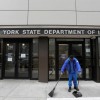 A person sweeps outside the entrance of the New York State Department of Labor offices,