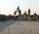 People walk near the national flag and the Metropolitan Cathedral on a Zocalo Square partially empty as the coronavirus disease (COVID-19) outbreak continues, in Mexico City