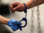 A U.S. Immigration and Customs Enforcement's (ICE) Fugitive Operations Agent takes handcuffs off before booking an immigrant in Los Angeles